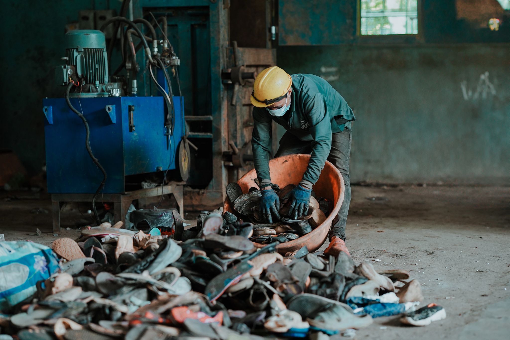 Worker sorting footwear waste in recycling facility